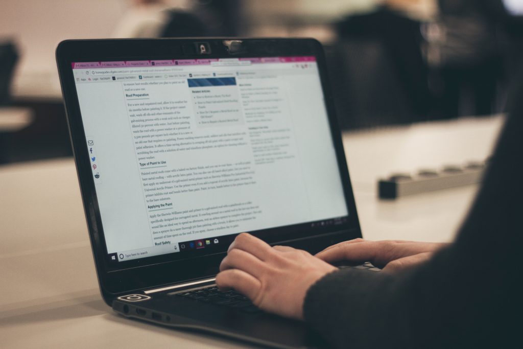 A person typing on a black Windows 10 powered computer