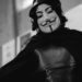 A black and white photo of a person wearing anonymous mask