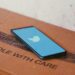 A phone placed on a card board box with Twitter app's Splash screen logo